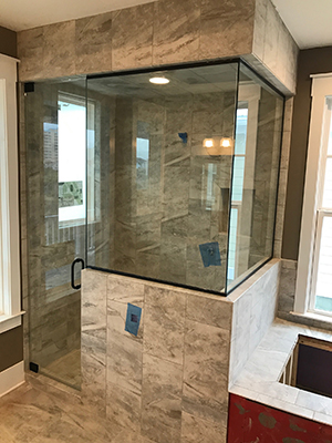 Custom glass shower door with polished hardware
