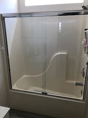 Glass shower enclosure with brushed hardware
